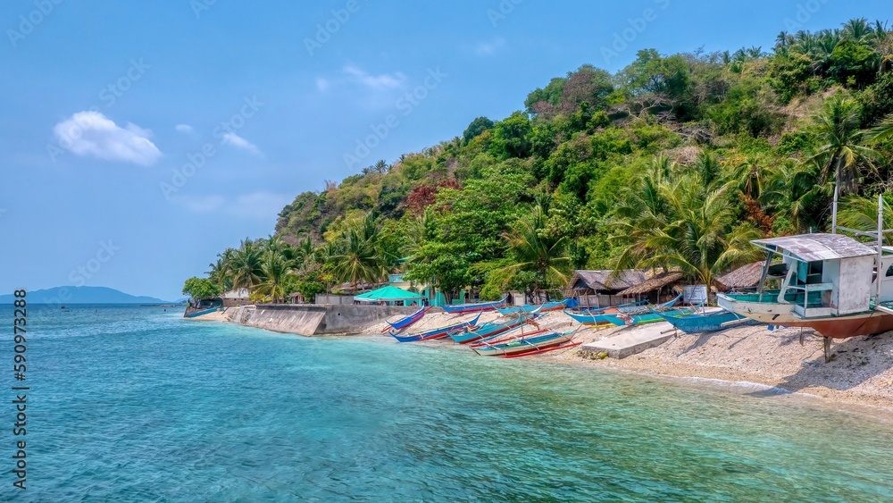 Obraz premium A picturesque fishing village with colorful wooden banca boats on the beach, located in San Antonio Barangay on Verde Island, Batangas Province, in the Philippines.