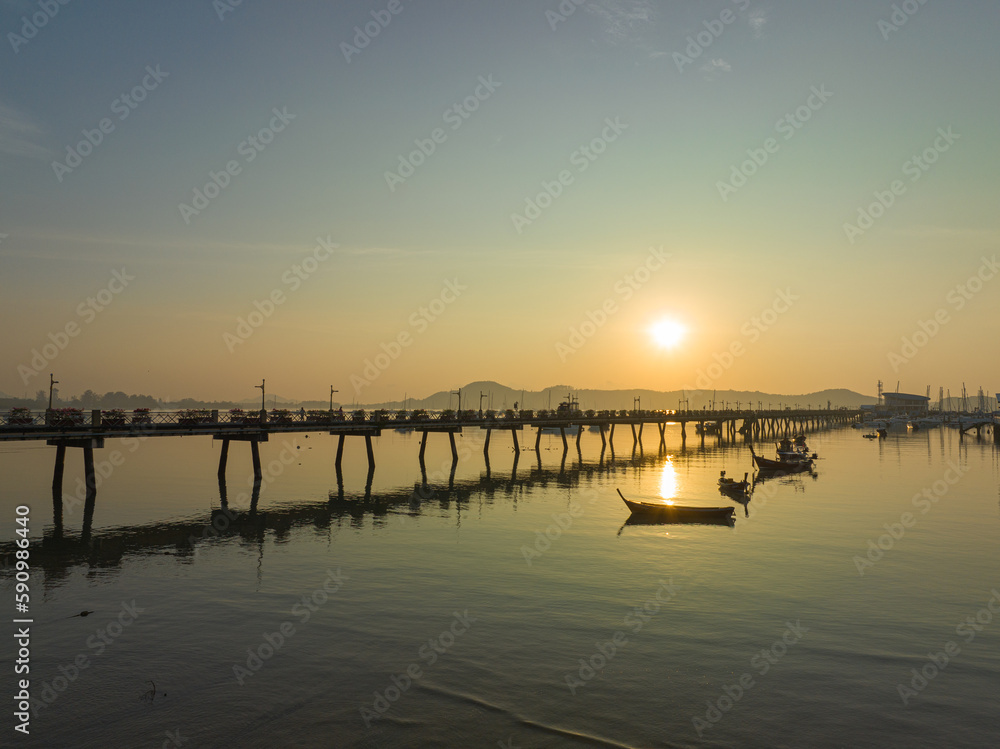 aerial view beautiful sunrise cloud above Chalong pier..Sunrise with sweet yellow color light rays and other atmospheric effects..colorful reflection of sunrise in the sea background.