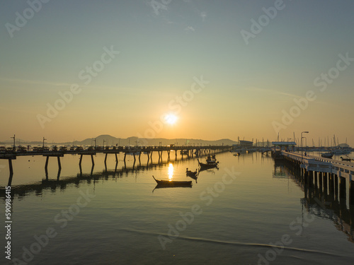 aerial view beautiful sunrise cloud above Chalong pier..Sunrise with sweet yellow color light rays and other atmospheric effects..colorful reflection of sunrise in the sea background. © Narong Niemhom