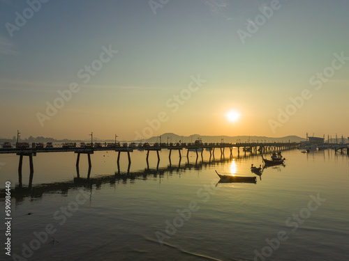 aerial view beautiful sunrise cloud above Chalong pier..Sunrise with sweet yellow color light rays and other atmospheric effects..colorful reflection of sunrise in the sea background. © Narong Niemhom