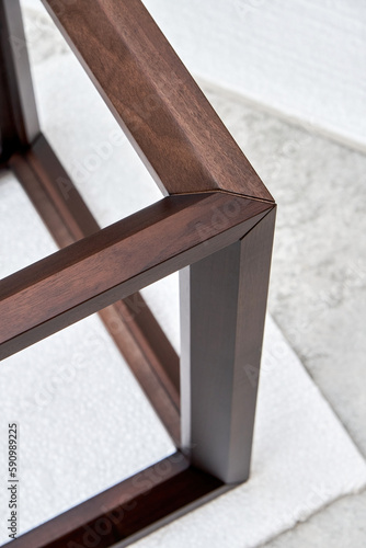 Wooden frame of bedside table made of solid walnut in workshop. Joinery angular joint of planks on dowels closeup