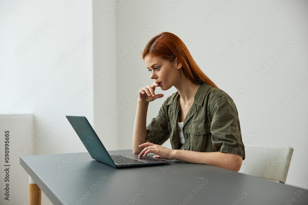 a woman sits at work at the table and looks thoughtfully, solving work issues in the office a woman sits at work at the table and looks thoughtfully, solving work issues in the office