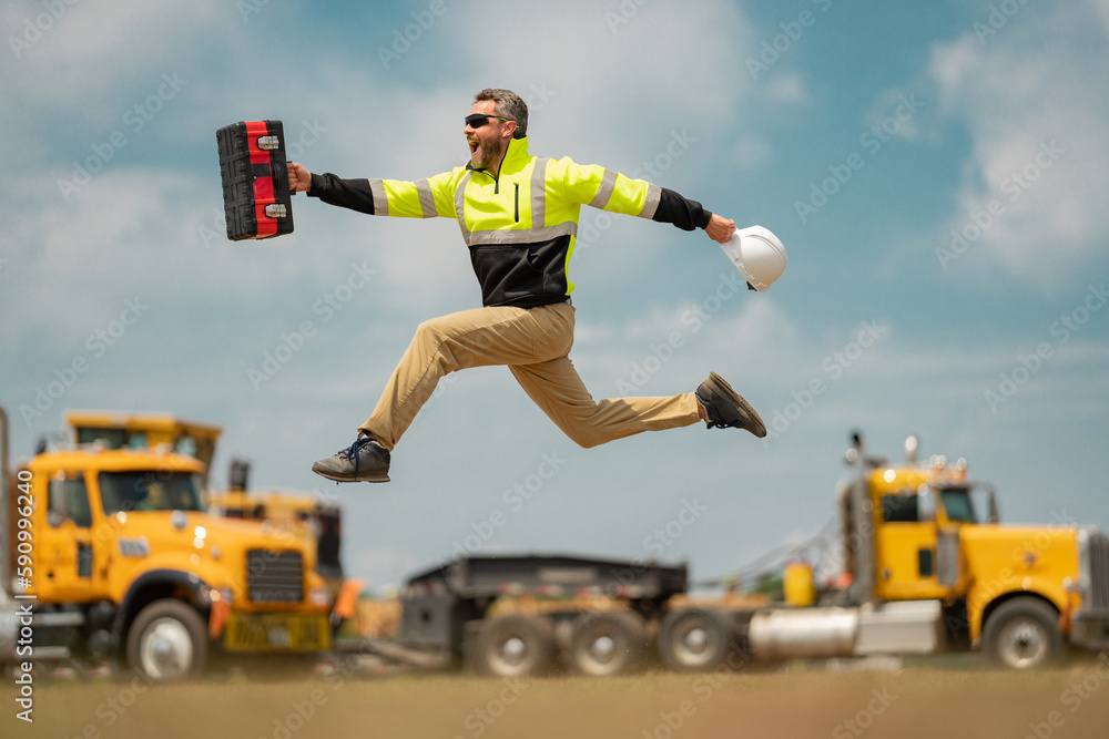Construction man excited jump with helmet. Worker at construction new building. Builder at construction site. Foreman workman portrait. Builder in helmet outdoor portrait. Worker in hardhat. - obrazy, fototapety, plakaty 