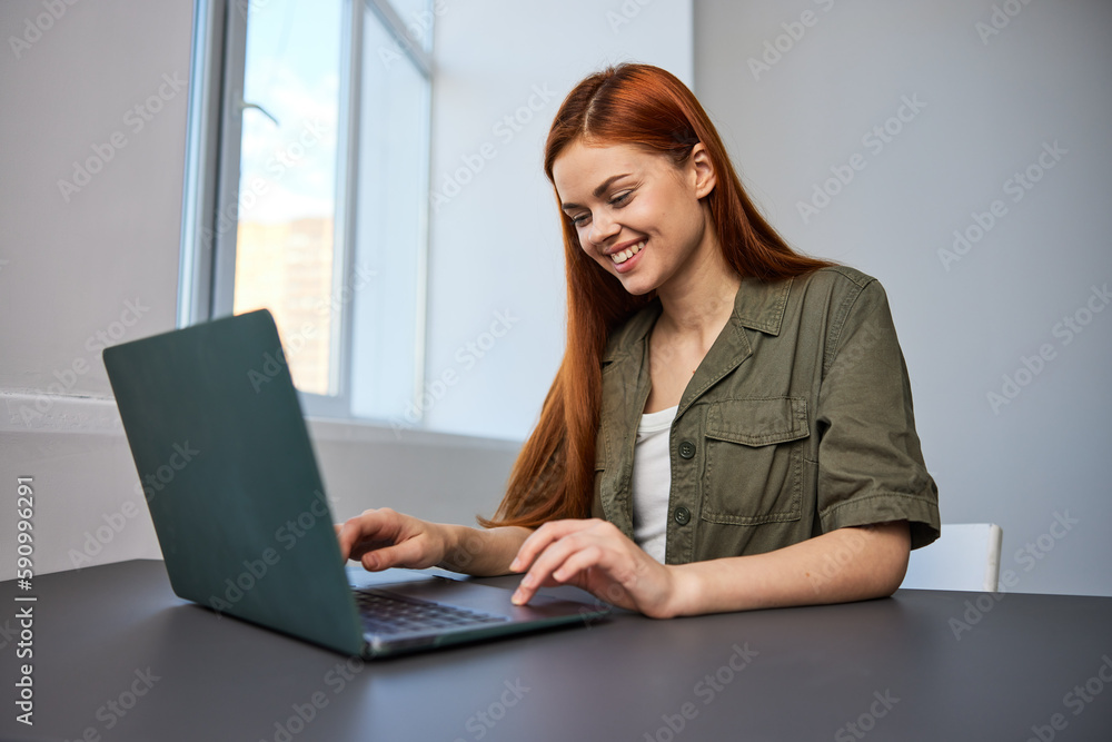 portrait of a happy, joyful woman sitting at a laptop and working in the office portrait of a happy, joyful woman sitting at a laptop and working in the office