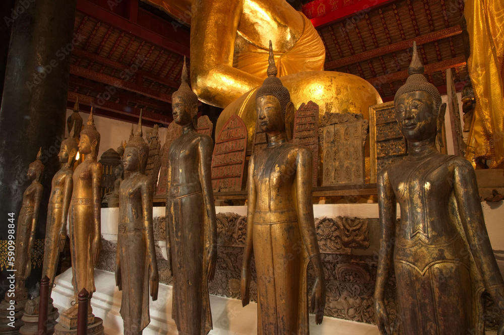 Fototapeta premium Groups of ancient Buddha images of various sizes gathered from various abandoned temples in Luang Prabang beside Luang Phor Tor in Wat Visounarath. Located at Luang Prabang Province in Northern Laos.