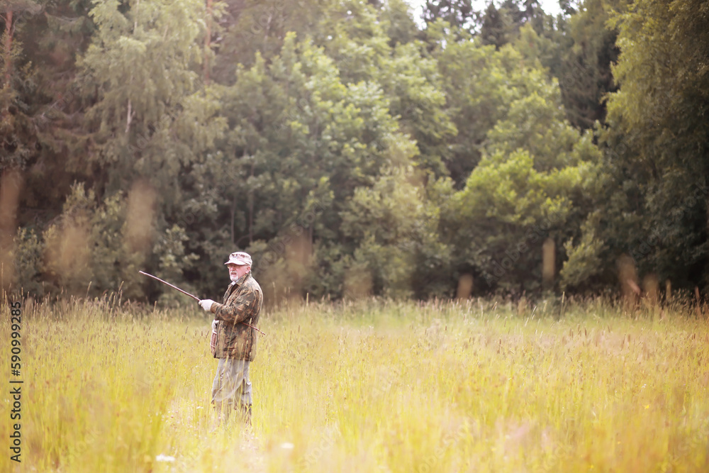 A man walks across the field into the forest for mushrooms. The mushroom picker goes to the forest. A man walks across the field into the forest for mushrooms. The mushroom picker goes to the forest.