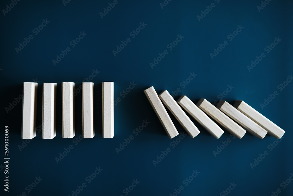 Closeup thick domino wood block in a row stop the falling, be stable in crisis, business solution concept Closeup thick domino wood block in a row stop the falling, be stable in crisis, business solution concept