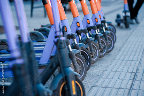 Electric scooters are parked in the city center. Modern public mobile transport