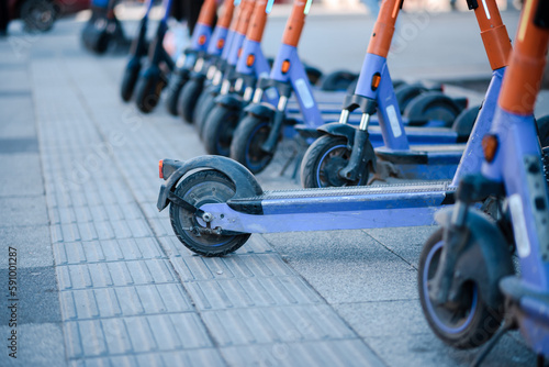 Electric scooters are parked in the city center. Modern public mobile transport