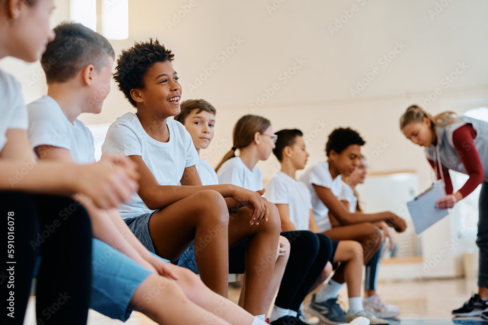 Happy black boy and his classmates during PE class at school gym. Happy black boy and his classmates during PE class at school gym.
