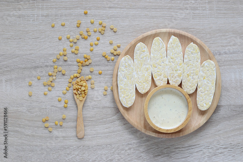 Raw tempeh, Top view of chickpeas tempeh and salad dressing in a bowl on wooder background, Healthy eating concept