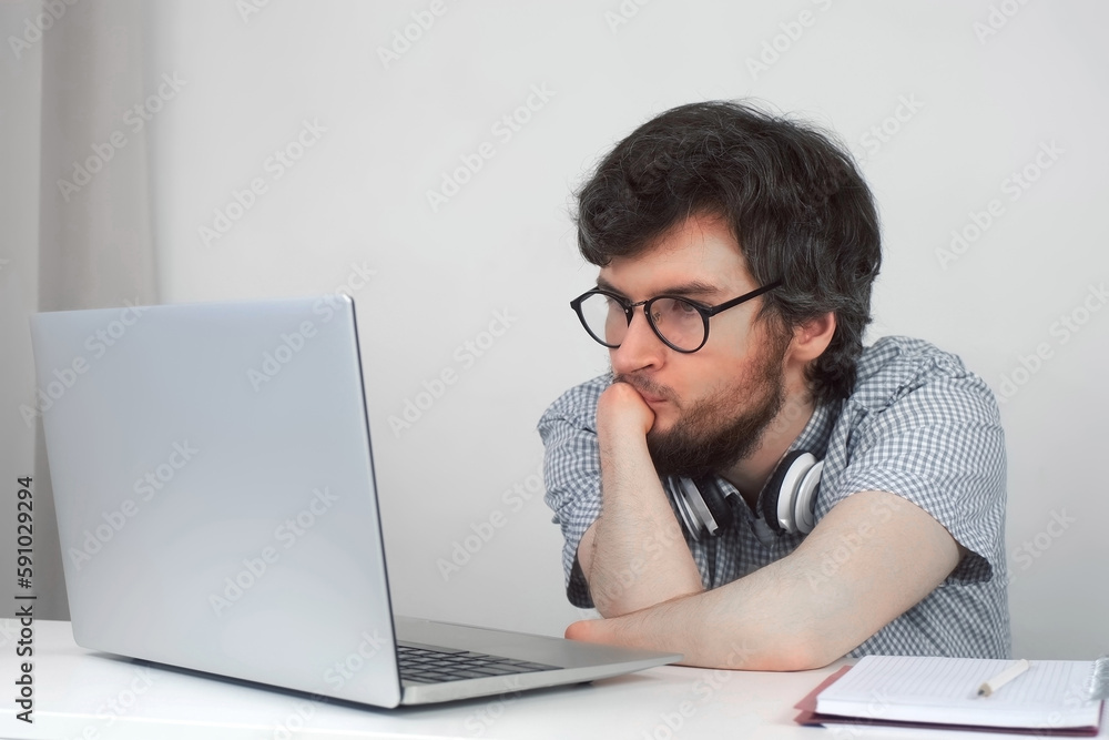 Disabled man in glasses with amputated two stump hands studying on laptop at home, distance education. Problem of adaptation to life people with disabilities. Independent Invalid person. Disabled man in glasses with amputated two stump hands studying on laptop at home, distance education. Problem of adaptation to life people with disabilities. Independent Invalid person.