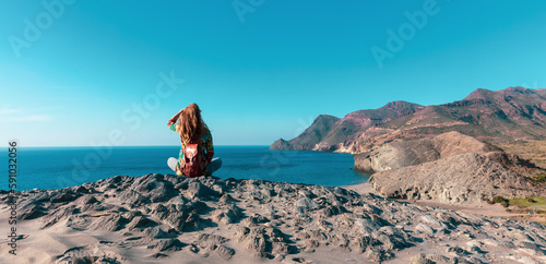 Woman sitting on rock looking at panoramic view of mediterranean sea- Andalusia in Spain © M.studio