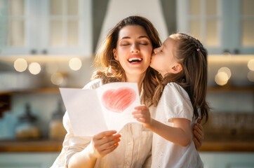 Daughter giving mother postcard.