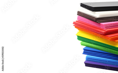 Stack of colorful corrugated plastic sheets isolated on white background with space on left