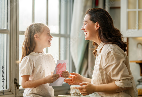 Daughter giving mother postcard.