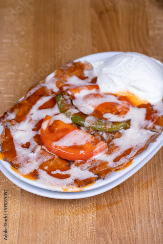 iskender kebab. iskender kebab with butter and yoghurt on a wooden floor. Turkish cuisine delicacies. Food tourism. Close up