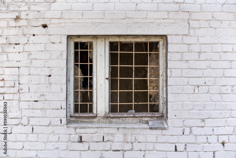 brick wall of a house with a window and a lattice in Ukraine