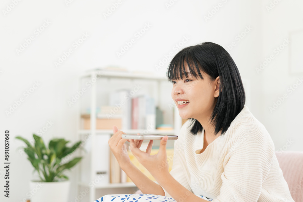 Asian teenager voice assistant with smartphone at home