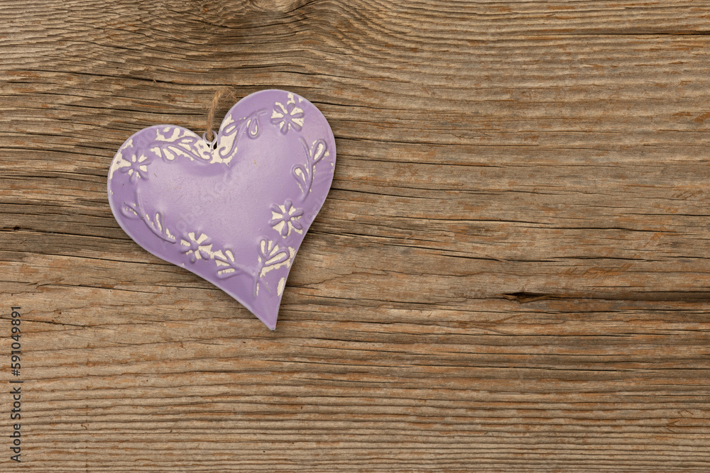 purple metal heart on rustic brown wooden background with free space for text