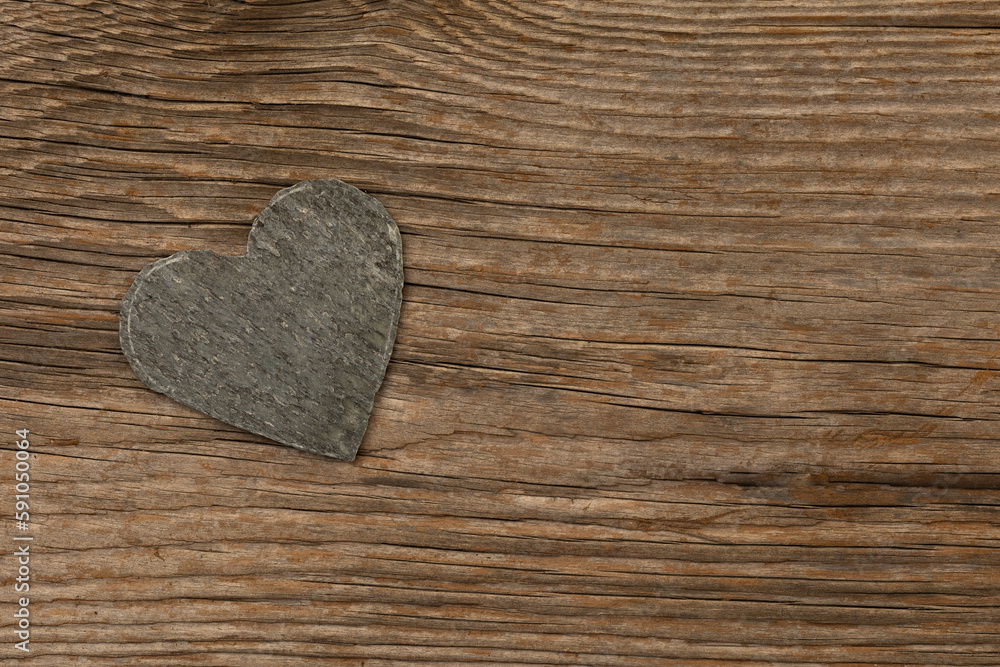 gray slate heart on rustic brown wooden background with free space for text gray slate heart on rustic brown wooden background with free space for text