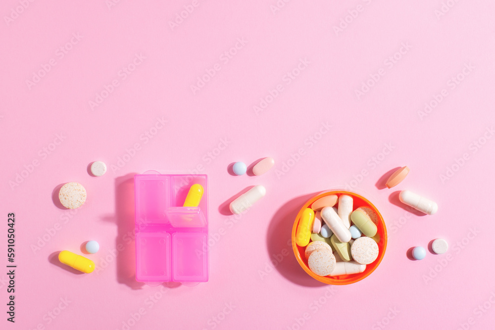 Pharmaceutical medicine pills, tablets, capsules, dietary supplements and pill box on brightly lit pink background with copy space. Pharmaceutical medicine pills, tablets, capsules, dietary supplements and pill box on brightly lit pink background with copy space.