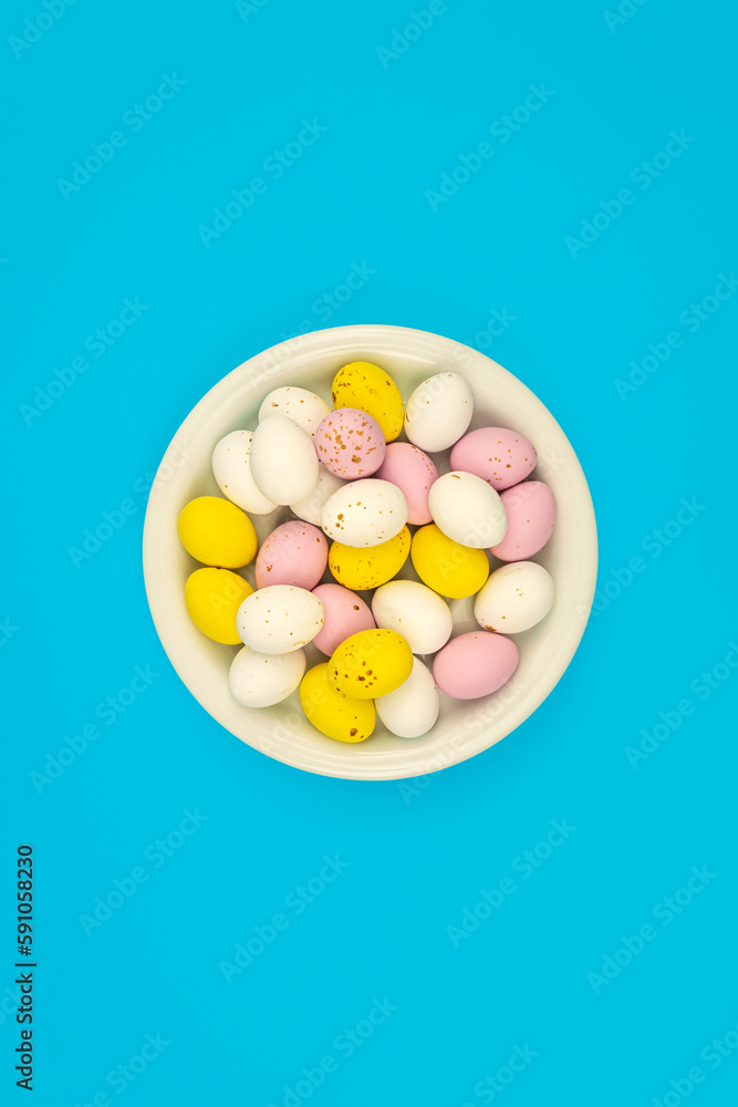 Obraz premium Plate with Easter eggs on a blue background, top view.