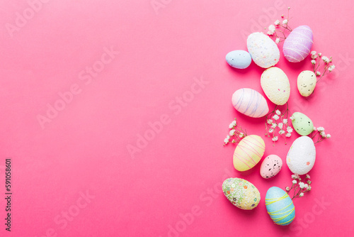 Happy Easter composition. Easter eggs on colored table with gypsophila. Natural dyed colorful eggs background top view with copy space