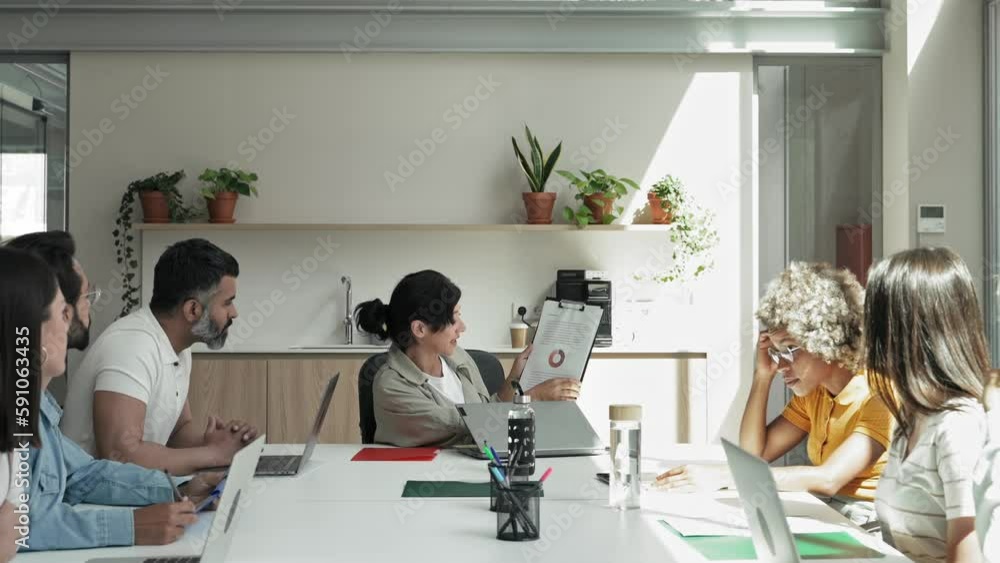 Female entrepreneur explaining business results to colleagues in meeting room. Businesswoman working together with diverse team Female entrepreneur explaining business results to colleagues in meeting room. Businesswoman working together with diverse team