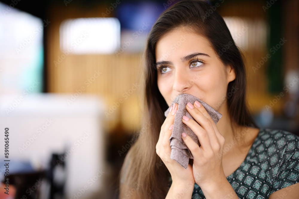 Woman cleaning mouth with napkin in a restaurant Woman cleaning mouth with napkin in a restaurant