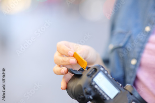 Photographer insterting sd card on camera