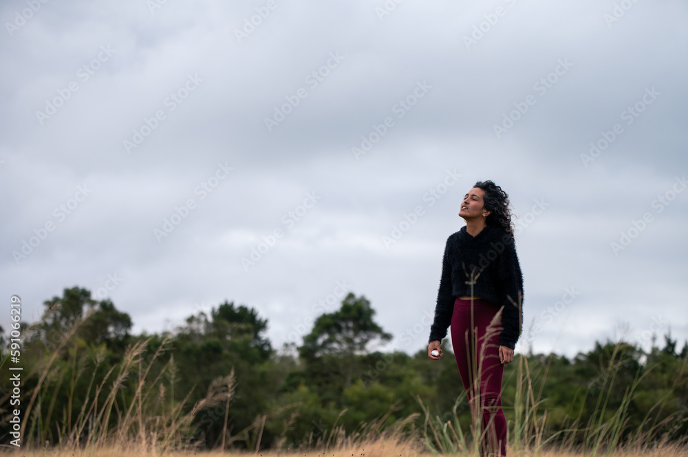 Woman standing in field with vaporizer in hand Woman standing in field with vaporizer in hand