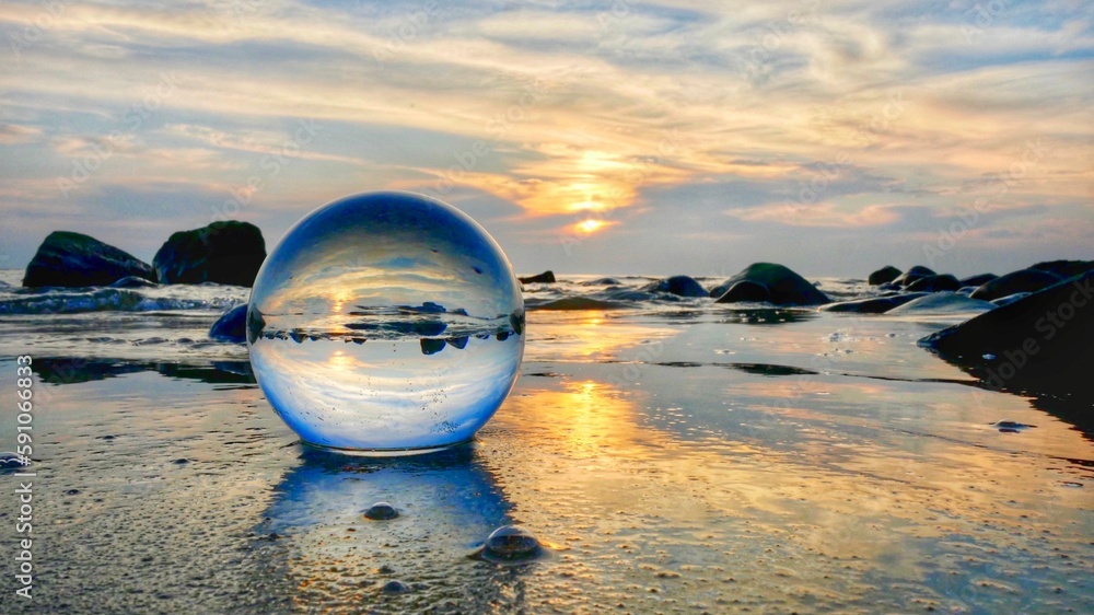 Crystal ball on the beach against a sunset Crystal ball on the beach against a sunset