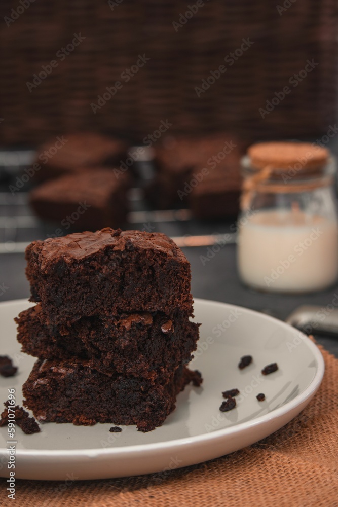 Selective focus of Chocolate brownie slice on white plate with blur background Selective focus of Chocolate brownie slice on white plate with blur background