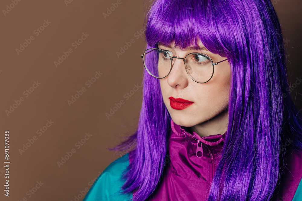 Stylish woman with purple hair in glasses and vintage track suit on brown background Stylish woman with purple hair in glasses and vintage track suit on brown background