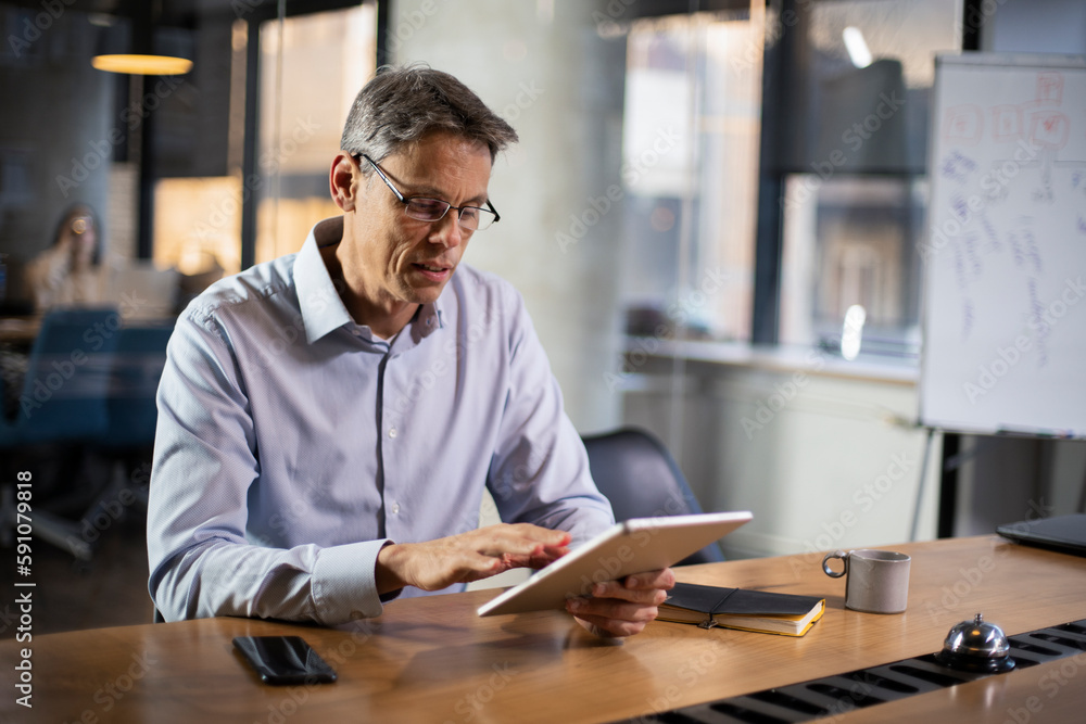 Portrait of businessman in office. Man using digital tablet. Businessman having video call.