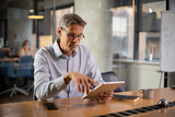 Portrait of businessman in office. Man using digital tablet. Businessman having video call.