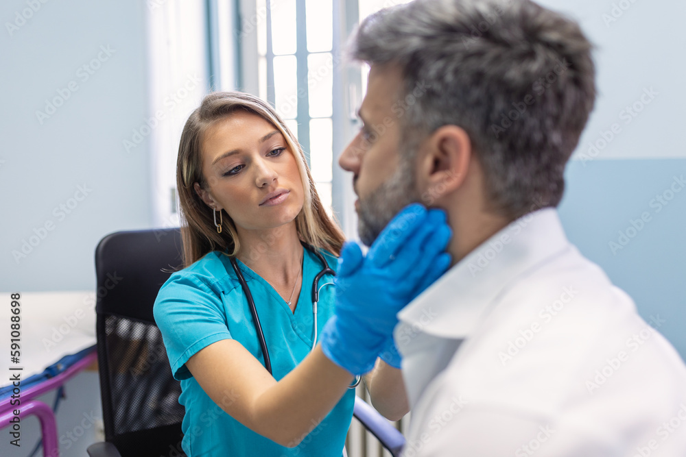 Fototapeta premium Endocrinologist examining throat of man in clinic. Men with thyroid gland test . Endocrinology, hormones and treatment. Inflammation of the sore throat
