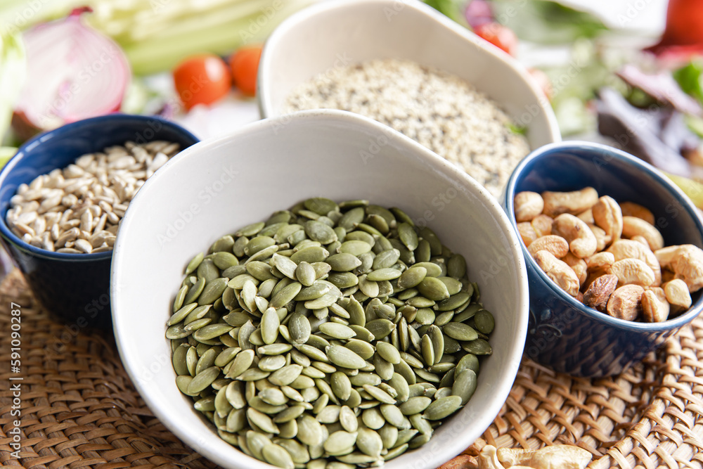 Close-up, a bowl of pumpkin seeds and other healthy foods on the kitchen table. Close-up, a bowl of pumpkin seeds and other healthy foods on the kitchen table.