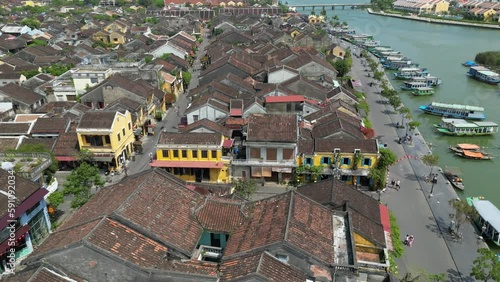 Beautiful drone footage in Hoi An ancient town along the riverside in central Vietnam. Camera is moving foward above the river and the roofs of the old city. 3-3 photo