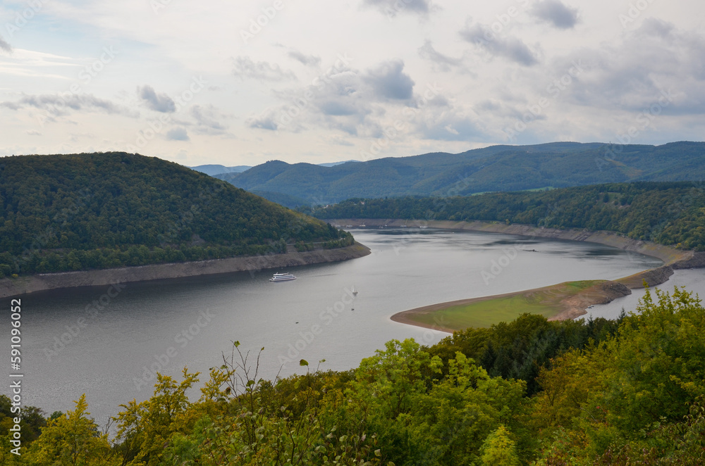 View of the mountain landscape at the Edersee with cloudy sky View of the mountain landscape at the Edersee with cloudy sky