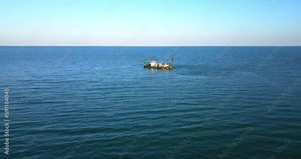 Ship to suck up the sand near a dike Ship to suck up the sand near a dike
