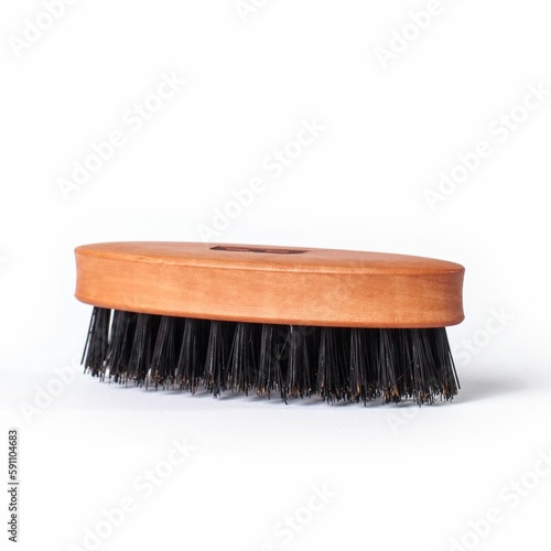 Wooden brush with black bristles and an engraved letter "B" isolated on a white background