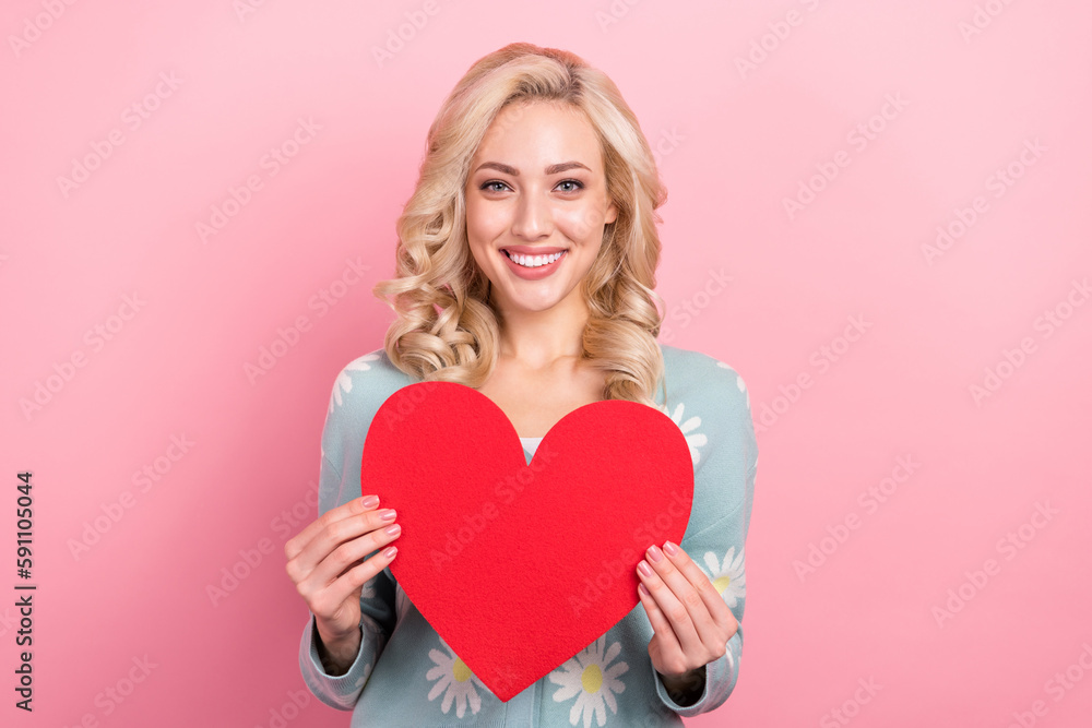 Portrait of positive gorgeous girl toothy smile arms hold paper heart card isolated on pink color background Portrait of positive gorgeous girl toothy smile arms hold paper heart card isolated on pink color background