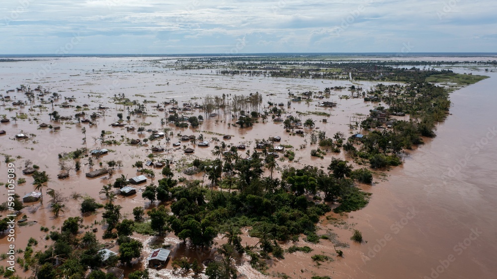 Big flood with trees and a village in the dirty waters in Africa