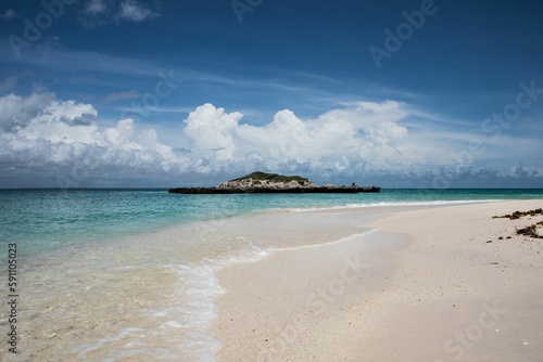 Fototapeta Naklejka Na Ścianę i Meble -  Sandy beach and the calm sea with a small island In the background in Okinawa, Japan