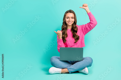 Full length photo of positive cheerful girl wear pink sweater working gadget thumbs empty space isolated turquoise color background © deagreez
