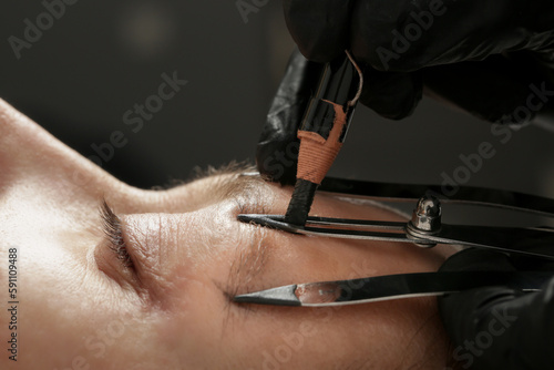 Mikrobleiding eyebrow measurement. Cosmetologist makes markings with pencil and threads for perfect shaped eyebrows. Professional makeup and facial care. Permanent makeup, tattooing of eyebrows.  photo
