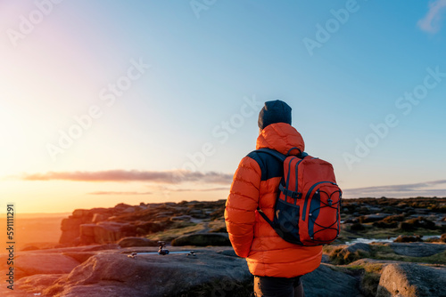 Bearded Man reaching the destination and on the top of mountain at sunrise or sunset on cold day Travel Lifestyle concept The national park Pick District in England
