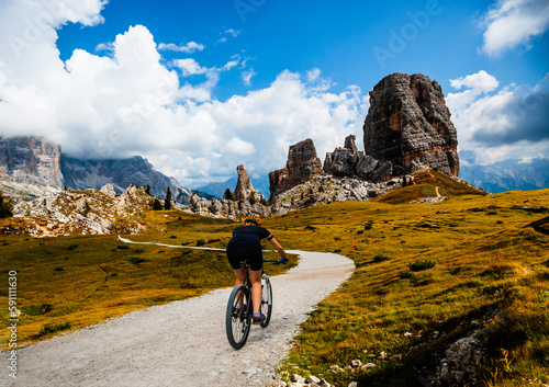 Woman ride electric mountain bikes in the Dolomites in Italy. Mountain biking adventure on beautiful mountain trails.